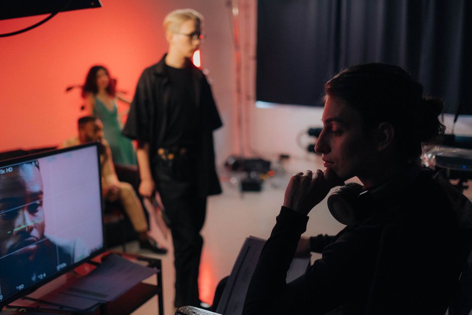 Creative professionals collaborating on a dynamic studio set with vibrant lighting.