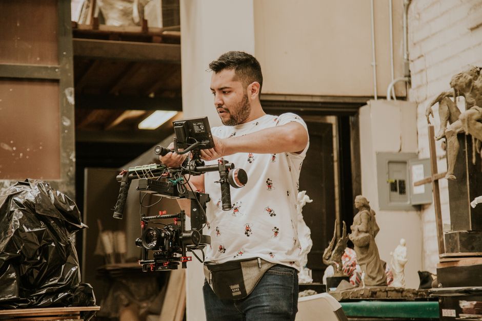 A filmmaker uses high-end camera equipment in a studio setting, capturing cinematic scenes.