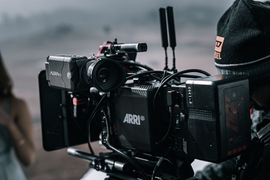 Close-up of a professional filmmaking camera setup on an outdoor set with blurred background.