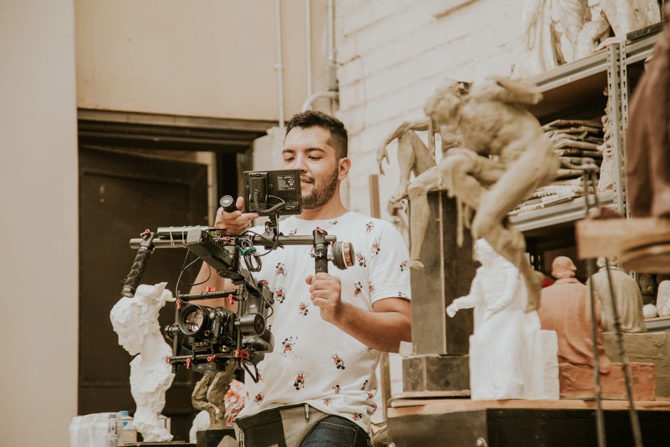 Videographer capturing creative scenes with professional camera equipment in an art studio.