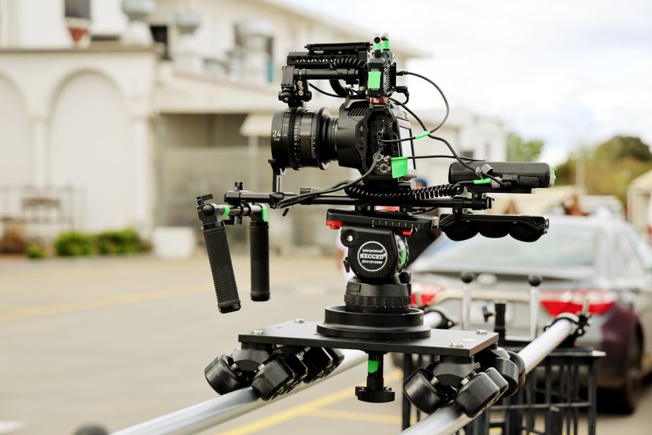 High-end camera rig mounted on a dolly track for film production outdoors.