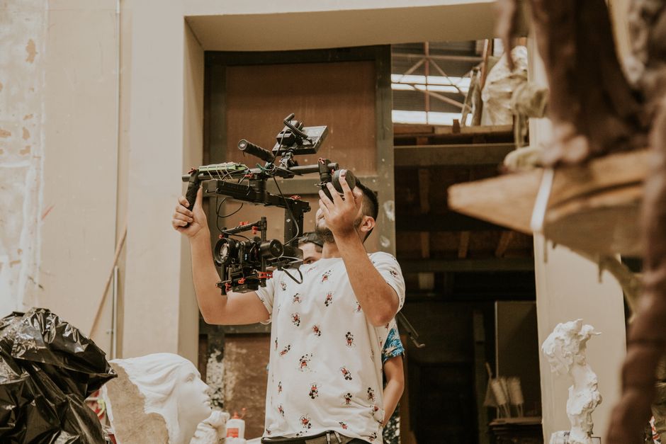 Professional camera operator handles a dynamic camera rig in an artistic studio setting.