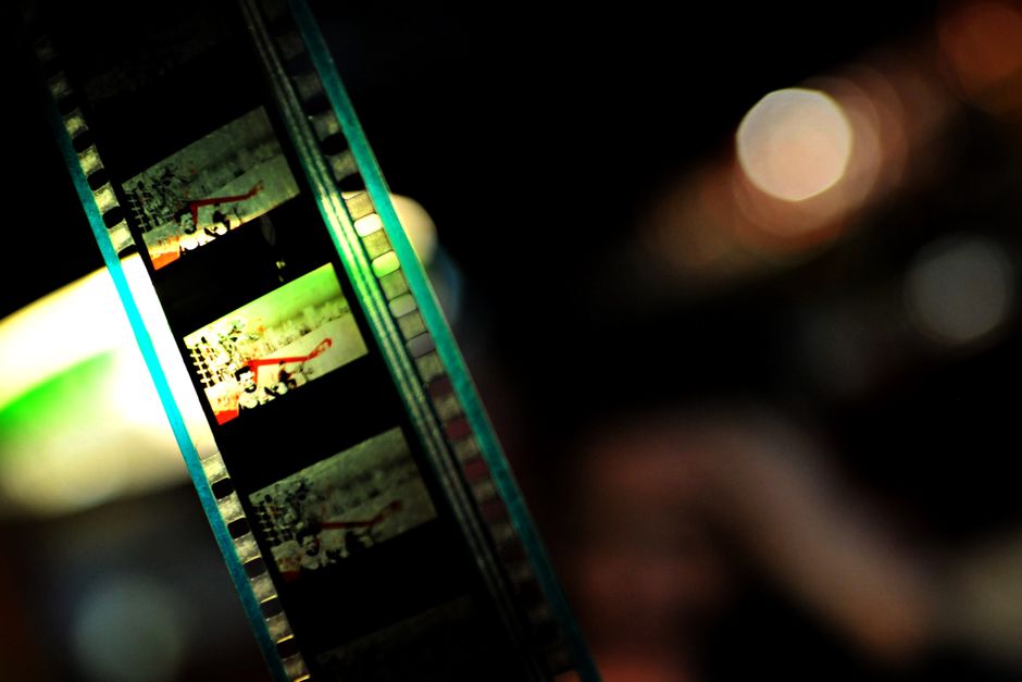 Close-up of a vintage film reel showcasing vibrant colors and cinematic art, highlighting the essence of classic filmmaking.