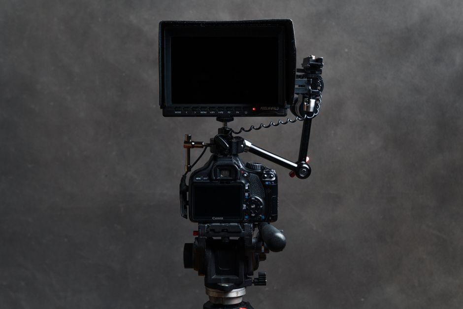 High-quality video camera with attached monitor and tripod, ideal for filming.