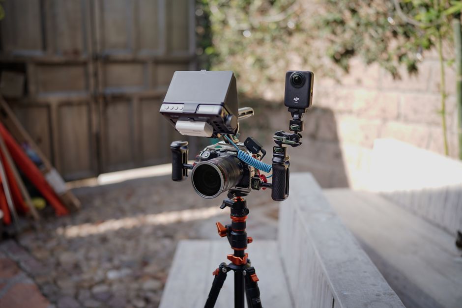 Close-up of a professional camera on a tripod with an attached monitor outdoors. Ideal for film production.