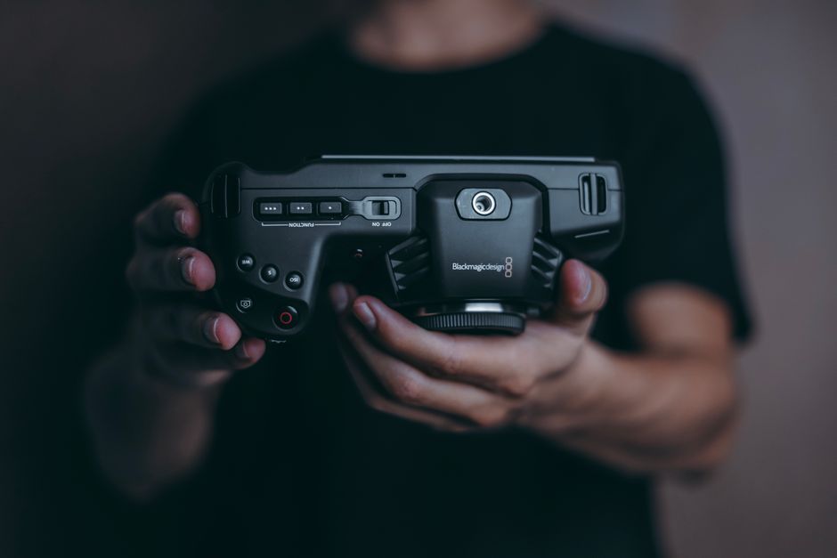 Detailed close-up of a person's hands holding a modern camera device.