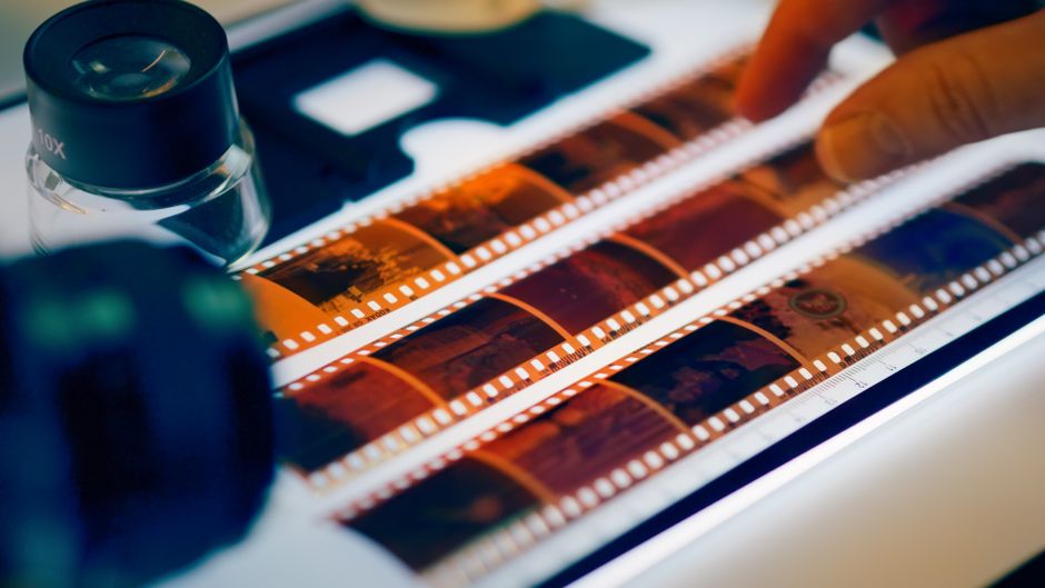 Close-up of film negatives being scanned with professional equipment in a studio setting.