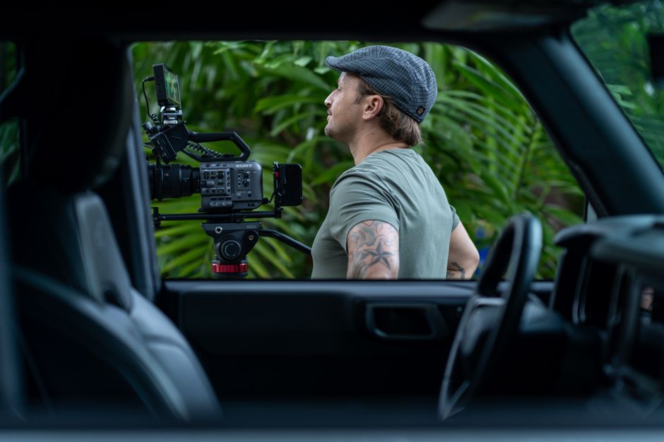 A cinematographer with camera filming outdoors in Fort Lauderdale, showcasing professional video production.