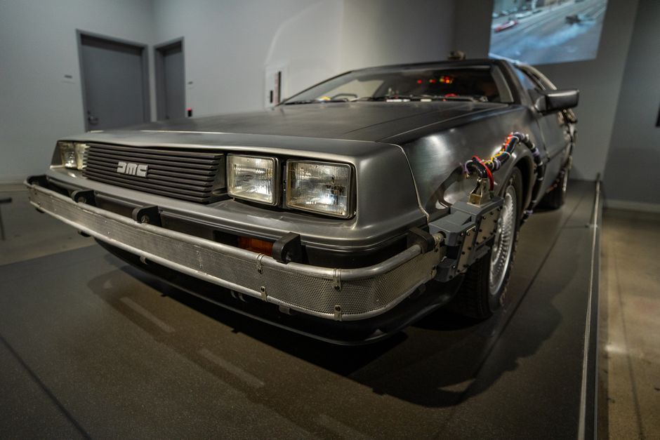 A DeLorean DMC-12 car converted into a time machine, exhibited indoors with retro details.
