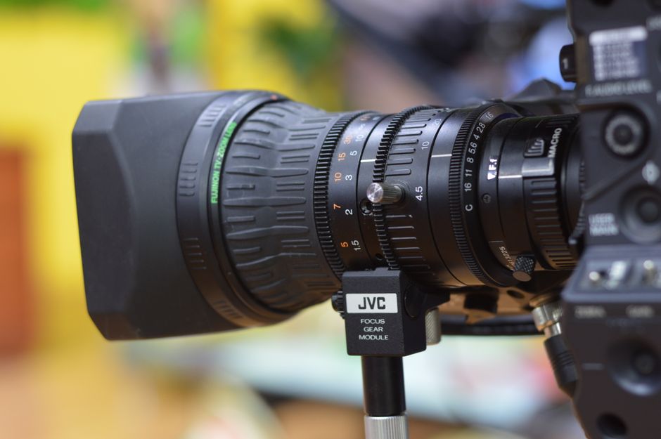 Detailed close-up of a professional camera lens with focus gear module, ideal for video production.