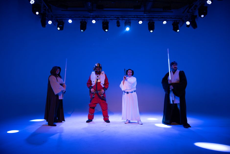 Group in Star Wars costumes on a blue-lit stage, perfect for film and entertainment concepts.