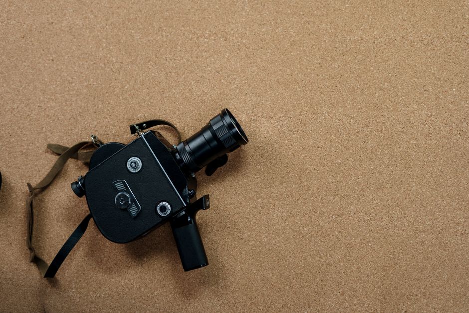 Vintage analog film camera on a cork board, perfect for cinematic or photography concepts.