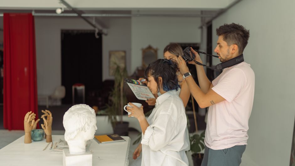 Creative photography session in İstanbul studio featuring sculptures and filming crew.