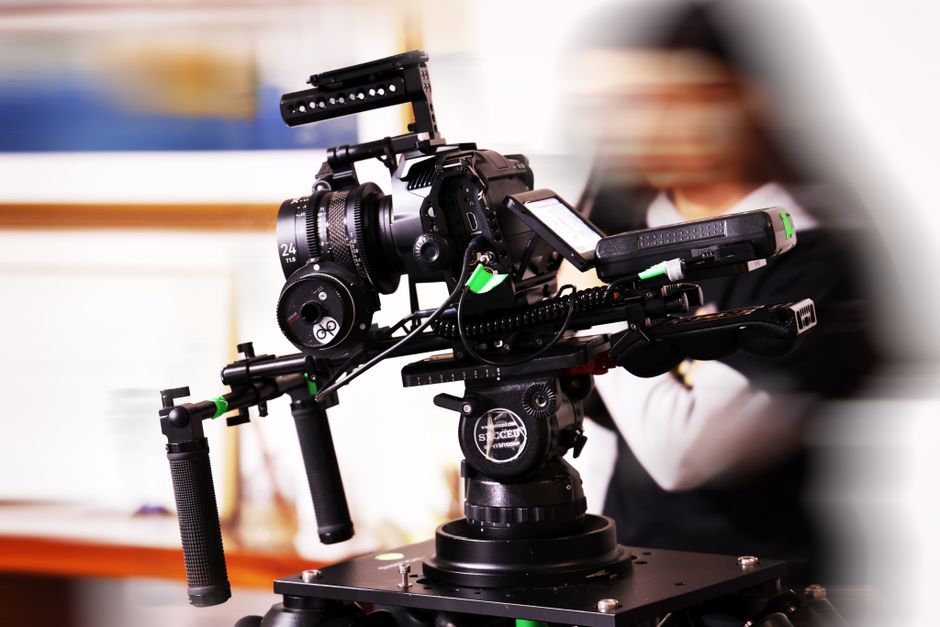 High-end video camera rig in a studio environment with blurred background, capturing cinematic moments.