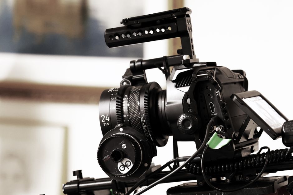 Close-up of a professional video camera rig in a studio setting, capturing cinematic scenes.