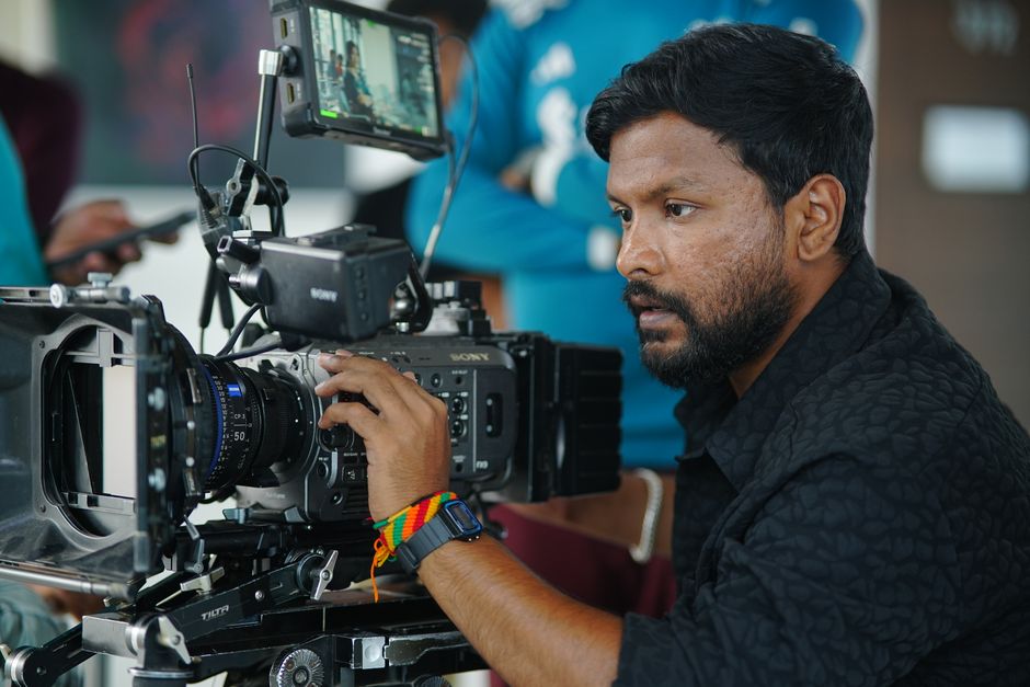 Focused cameraman operating professional video equipment indoors in Dhaka.