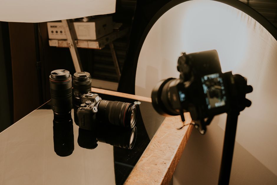 A detailed view of a professional camera setup with lenses and lighting in a studio environment.