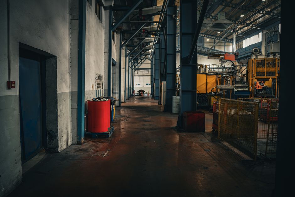 Moody industrial interior showcasing spaciousness and machinery in an empty factory setting.