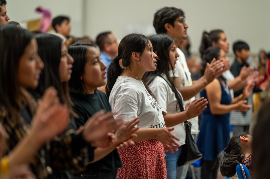 A diverse group of people standing and clapping at a cultural event in Ciudad de México, CDMX.