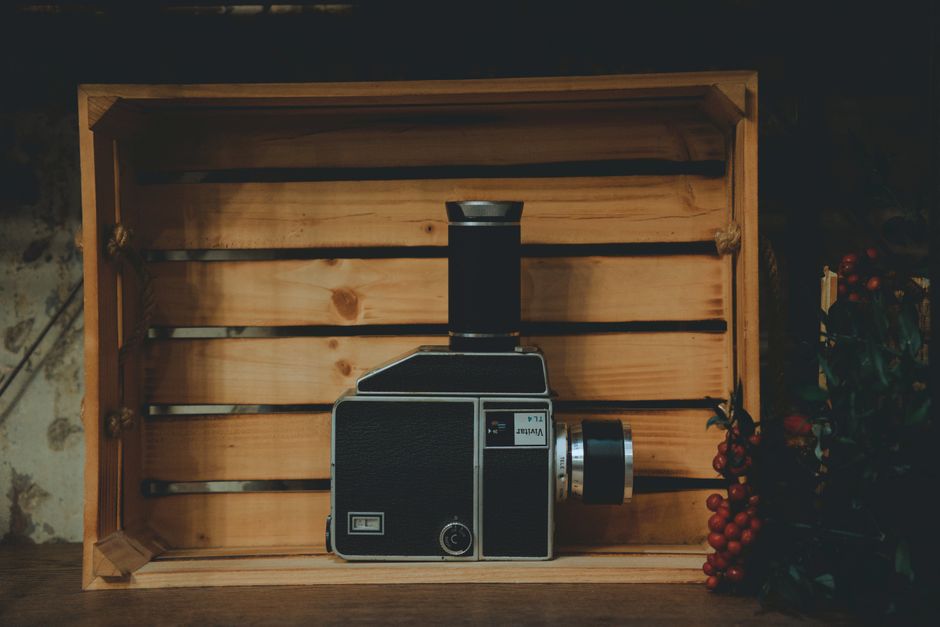 Close-up of a retro camera inside a wooden box, showcasing classic style.