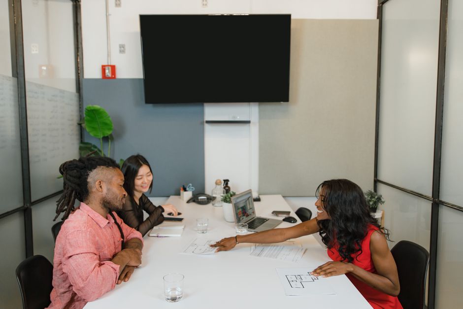 Three professionals engaged in a collaborative meeting in a modern office setting.