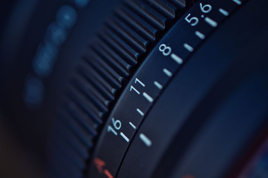 Detailed focus on a camera lens aperture ring, capturing f-stop numbers.