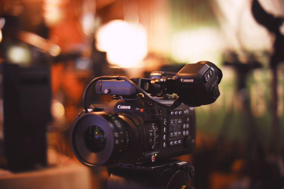 Close-up of a professional video camera with selective focus in a studio setting.