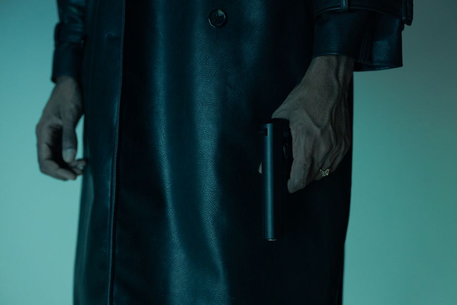 Close-up of an unrecognizable person holding a pistol, creating a mysterious and suspenseful mood.