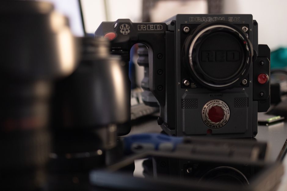 Close-up of a high-end film camera on a cluttered studio desk, highlighting professional video equipment.