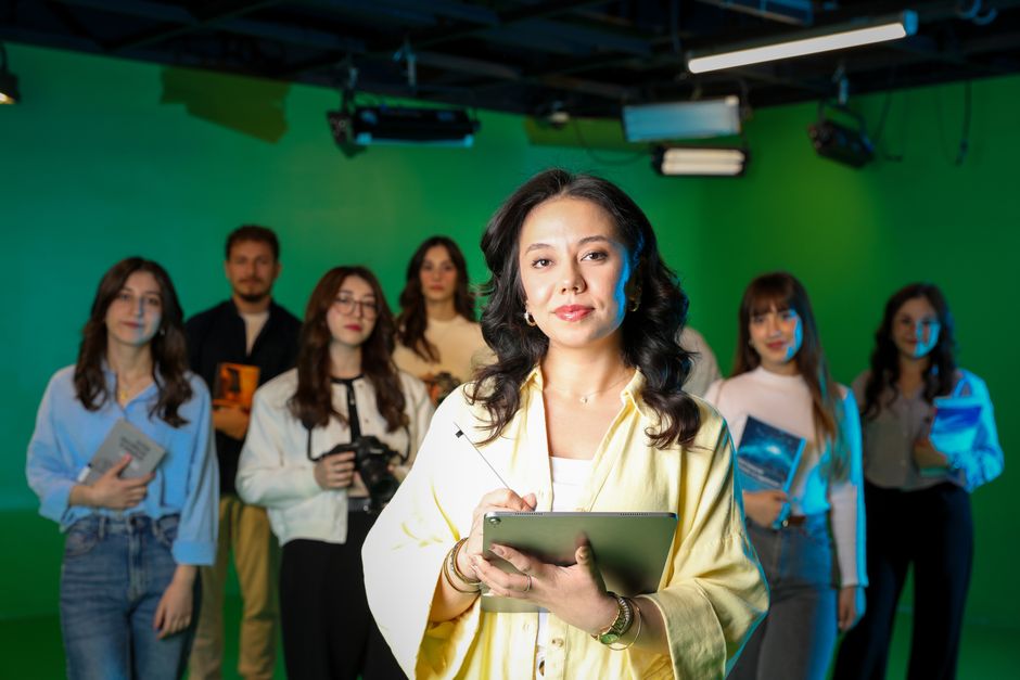 A diverse group of professionals working collaboratively in a green screen studio setting.