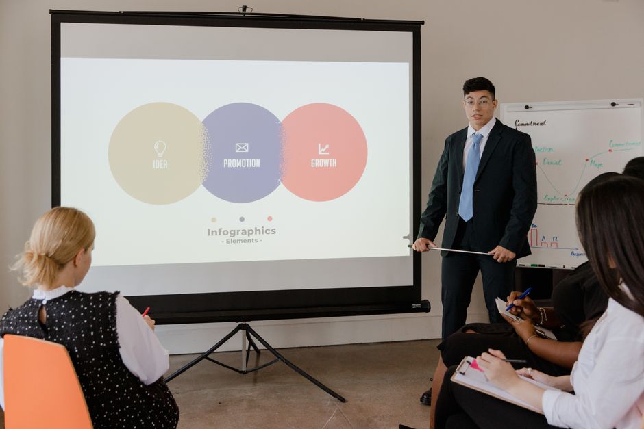 Professional business meeting with a presentation using visual infographics on a projector screen.