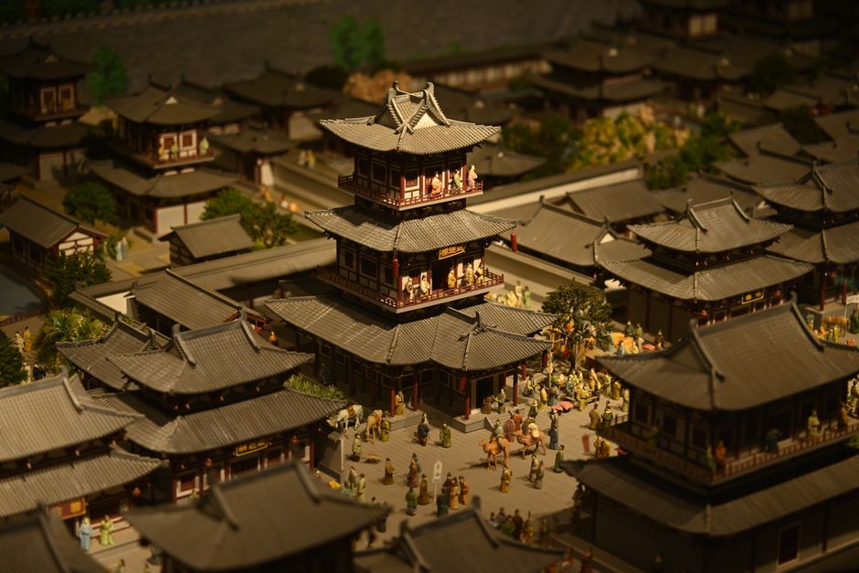 Detailed miniature model depicting traditional Asian architecture in a historical scene.