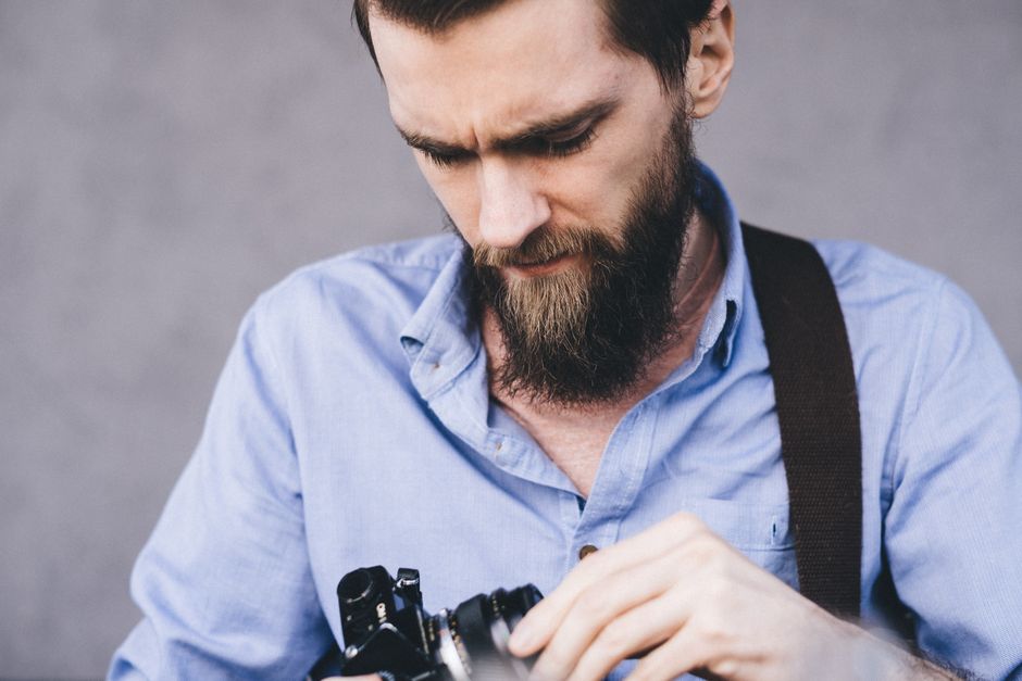 Close-up of a photographer adjusting camera settings outdoors.