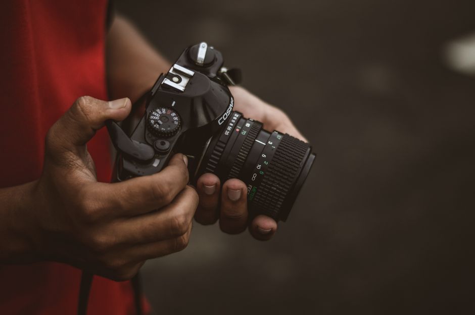 Detailed close-up of hands holding a vintage camera, perfect for photography enthusiasts.
