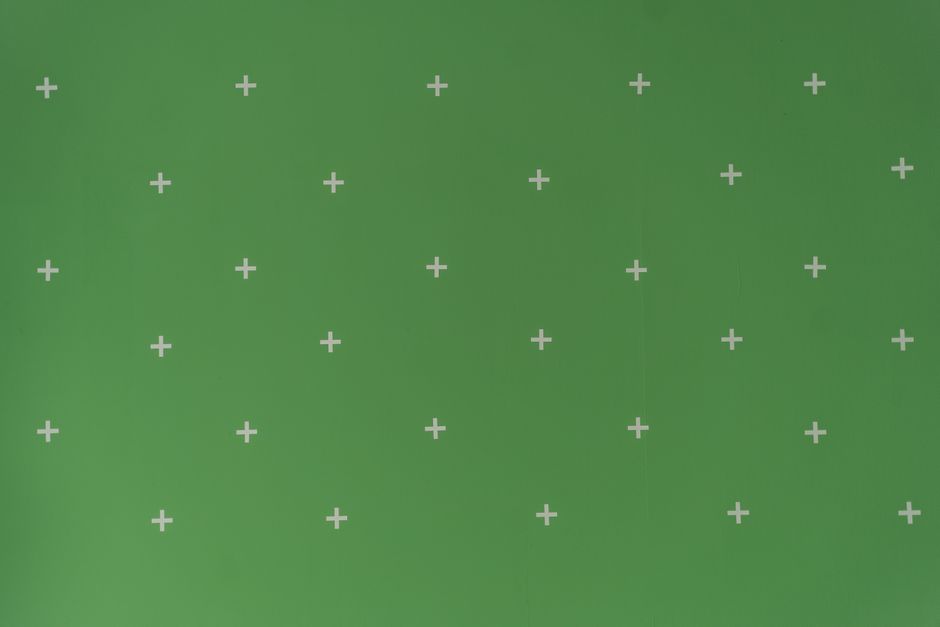 Green screen with white cross markers used for visual effects and post-production.