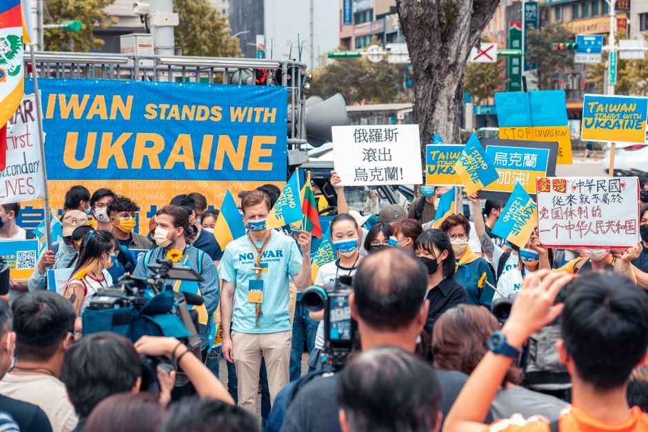 Group of Taiwan protesters rallying in support of Ukraine, holding signs and flags on the street.