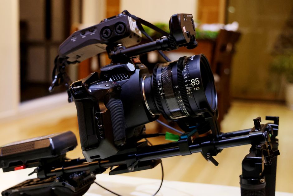 Close-up of a professional film camera rig with lens indoors, perfect for filmmaking and videography enthusiasts.