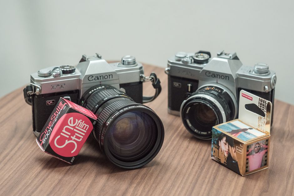 Two vintage Canon cameras with CineStill film on a wooden table, perfect for retro photography enthusiasts.