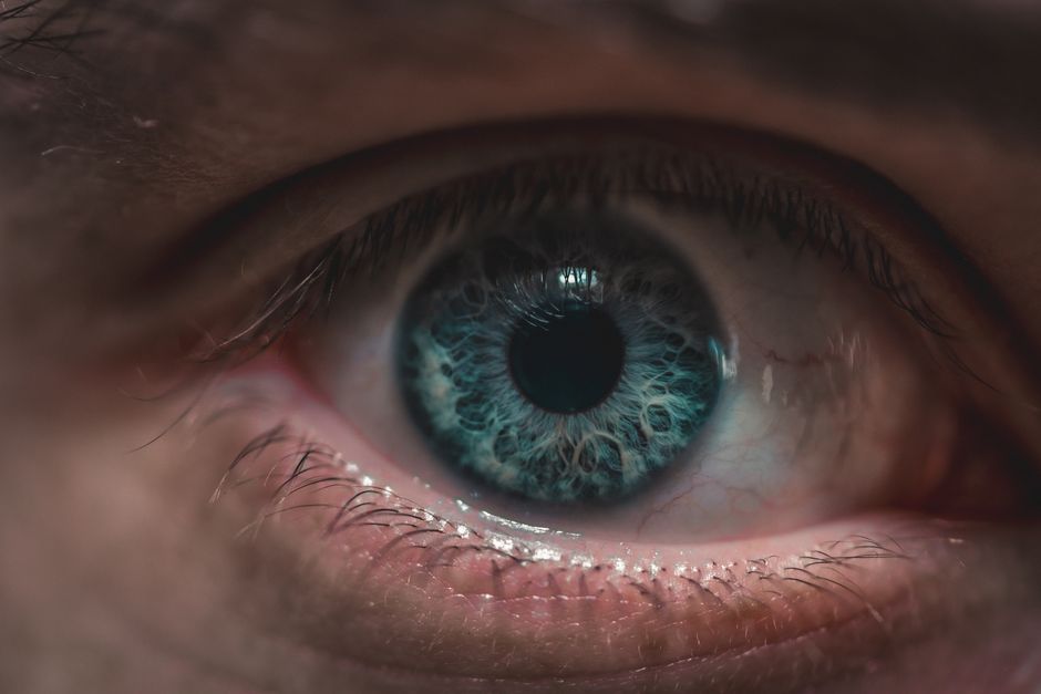 Extreme close-up image capturing the intricate details of a blue human eye with remarkable clarity.