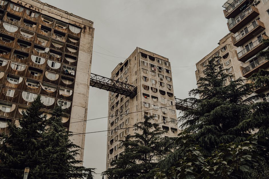 Low-angle view of distinct Soviet-era residential towers in Georgia showcasing brutalist architecture.