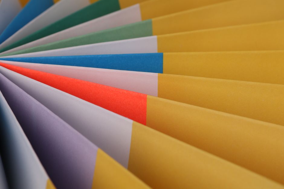 Close-up of a fan-shaped arrangement of colorful paper sheets, showcasing a vibrant and artistic design.