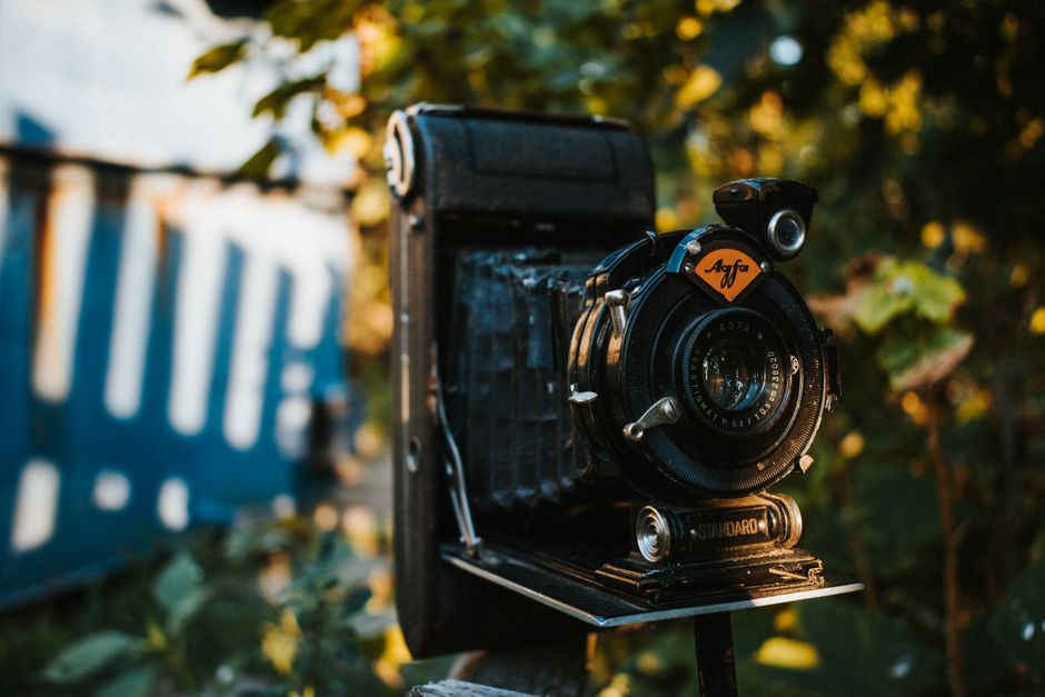Close-up of a vintage camera with a retro vibe in an outdoor setting.