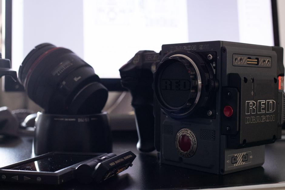 Red Dragon 5K camera and lens setup on a desk, perfect for video production enthusiasts.