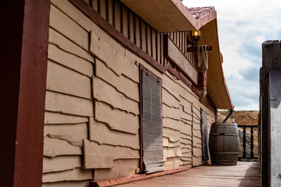 Wooden structure with textured siding and barrel, Malta. Warm tones and rustic charm.