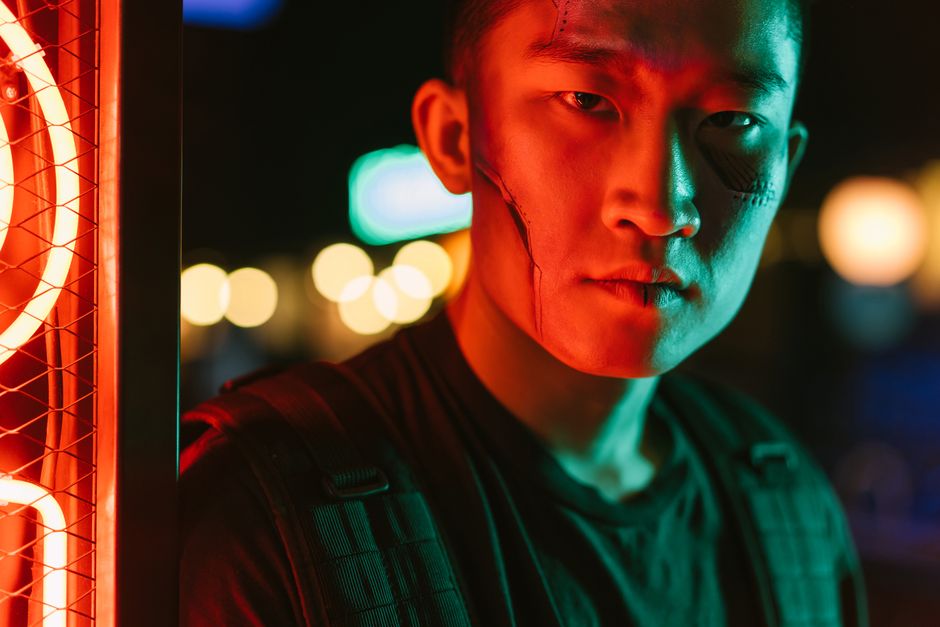 Close-up of a serious man in a cyberpunk setting with neon lighting and futuristic style.