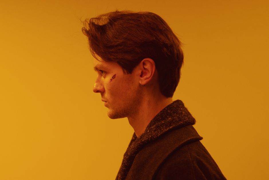 Artistic side profile of a man with a cyberpunk theme and orange background.