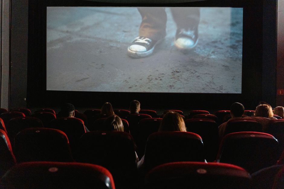 A group of people enjoying a film in a cinema with a large screen.