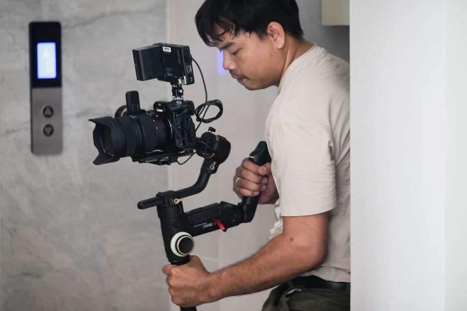 A videographer using a stabilizer indoors, focusing on precision filming.