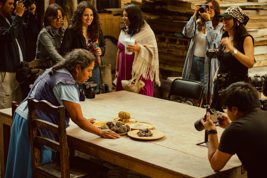 Artisan demonstrates traditional techniques in workshop setting, surrounded by attendees.