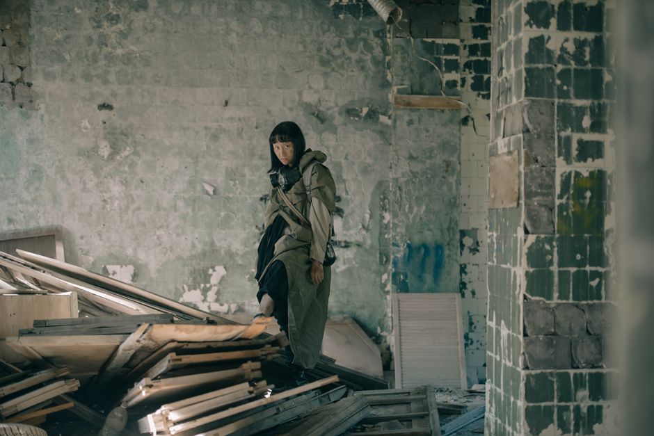 A person exploring a dilapidated building, symbolizing urban decay and apocalypse.